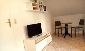 a living room with a flat screen tv on a cabinet at Fischstübchen Neeberg Apt 1 – Wald und Wiese in Krummin