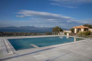 einen Pool mit Blick auf das Wasser in der Unterkunft Hestia in Áyioi Apóstoloi