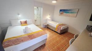 a small room with two beds and a bathroom at Sunburst Motel in Gold Coast