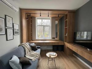 a living room with a blue couch and a television at Cathedral Park Modern studio in Chişinău