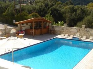 a large blue swimming pool with chairs and a gazebo at Hotel Rodini in Kato Rodini