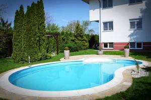 a swimming pool in the yard of a house at Hotel Weldi in Győr