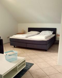 a bedroom with a bed and a tiled floor at Fischstübchen Neeberg Apt 2 – Meerjungfrau in Krummin