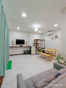a living room with a couch and a table at ทุ่งจับช้างโฮมสเตย์ in Pumriang