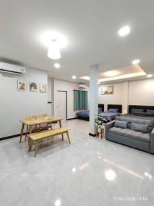 a living room with a couch and a table at ทุ่งจับช้างโฮมสเตย์ in Pumriang
