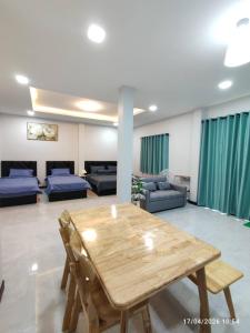 a living room with a wooden table and a couch at ทุ่งจับช้างโฮมสเตย์ in Pumriang