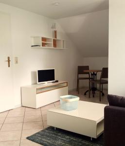a living room with a tv and a table at Fischstübchen Neeberg Apt 2 – Meerjungfrau in Krummin
