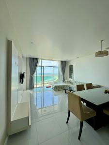 a dining room with a table and chairs and a view of the ocean at Hotel,Căn Hộ Mũi Né Sea link in Phan Thiet