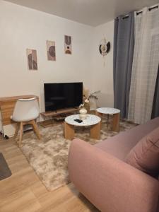 a living room with a couch and a tv at Résidences Eska in Bobigny