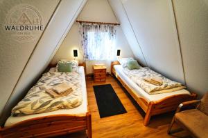 two beds in a small room with a window at Waldruhe 37 inkl Bettwäsche und Handtücher, schlüsselloser Self-Check-in in Bad Arolsen