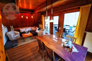 a dining room and living room with a wooden table at Waldruhe 37 inkl Bettwäsche und Handtücher, schlüsselloser Self-Check-in in Bad Arolsen