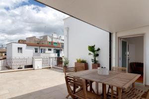 a patio with a wooden table and chairs on a balcony at Terrazza del Pittore in Gioia del Colle