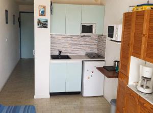 a kitchen with white appliances and a brick wall at El Rivet - appartement vue mer avec parking in Sète