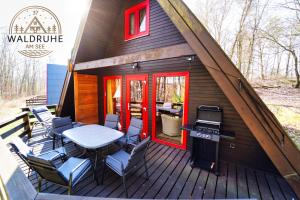 a small cabin with a table and chairs on a deck at Waldruhe 37 inkl Bettwäsche und Handtücher, schlüsselloser Self-Check-in in Bad Arolsen
