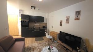 a living room with a couch and a kitchen at Résidences Eska in Bobigny