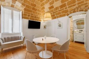a dining room with a white table and chairs at Terrazza del Pittore in Gioia del Colle