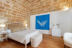 a bedroom with a bed and a brick wall at Terrazza del Pittore in Gioia del Colle