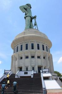 a statue on top of a building with people walking up the stairs at Quds Royal Hotel in Surabaya