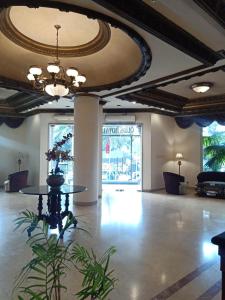 a large lobby with a table in the middle of a room at Quds Royal Hotel in Surabaya
