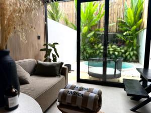 a living room with a couch and a table at NOMAD Chic Private Pool Loft in Canggu, all inclusive stay in Dalung