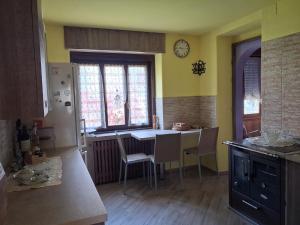 a kitchen with a table and chairs in a room at Dai Barèta in Dare