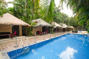 a large swimming pool with chairs and umbrellas at Pride Hotel & Convention Centre Indore in Indore