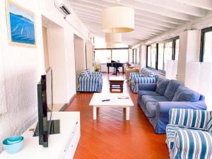 ein Wohnzimmer mit einem blauen Sofa und Stühlen in der Unterkunft Hotel Kinda in Castiglione della Pescaia