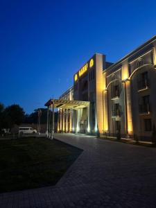 a lit up building with a parking lot in front of it at Lazgi Boutique & Spa Hotel in Khiva