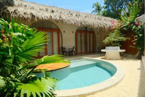 a resort with a swimming pool in front of a house at Lugadia Villas in El Nido