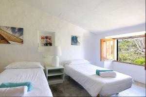 two beds in a white room with a window at Finca Es Coste by Rentallorca in Pollença +33 photos