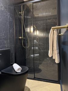 a bathroom with a shower with a toilet and towels at Suite Vendôme - Elégance, Terrasse avec accès Piscine in Villeréal