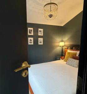 a bedroom with a large white bed with a chandelier at Suite Vendôme - Elégance, Terrasse avec accès Piscine in Villeréal