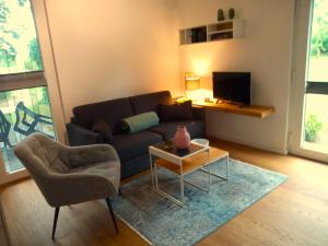 a living room with a couch and a table and a tv at Fischstübchen Neeberg Fewo 2 - Achterwasser in Krummin