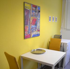 gelbes Zimmer mit einem weißen Tisch und Stühlen in der Unterkunft F2 - Am alten Elbarm - Laubegast in Dresden