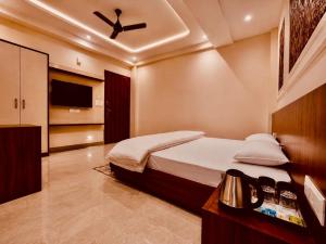 a bedroom with a bed and a ceiling fan at Ram Anandam inn in Ayodhya