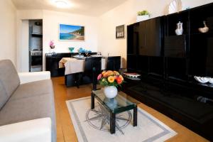 a living room with a vase of flowers on a glass table at Baja Sardinia Sea View And Pool B in Baja Sardinia