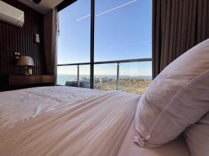 a bedroom with a large bed with a large window at Azurea Suites in Alexandria