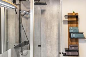 a shower with a glass door and some towels at Ruhige Einliegerwohnung mit Terasse in Altenkunstadt +27 photos