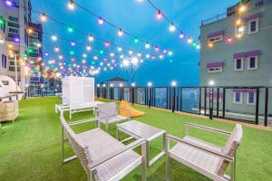 a patio with chairs and lights on a building at Samcheo Tayo Caravan in Samcheok