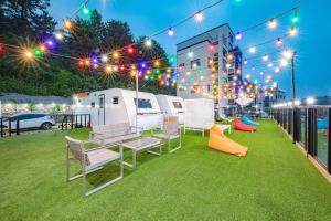 a patio with a group of chairs and lights at Samcheo Tayo Caravan in Samcheok