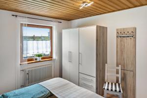 a bedroom with a bed and a cabinet and a window at Ruhige Einliegerwohnung mit Terasse in Altenkunstadt
