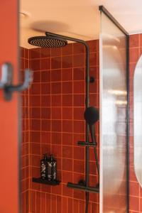 a shower with red tiles in a bathroom at Hotel Schani Naschmarkt - opening September 2026 in Vienna +18 photos