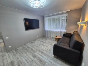 a living room with a couch and a flat screen tv at 2-room apartment with separate rooms in Narva