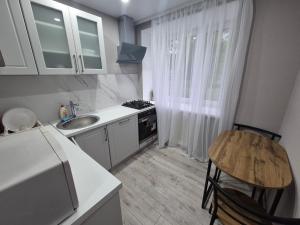 a small kitchen with a sink and a stove at 2-room apartment with separate rooms in Narva