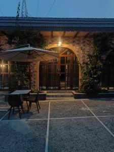 a table with an umbrella in front of a building at The Doghouse in Dehradun