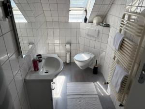 a white bathroom with a sink and a toilet at Appartement am Peterstor in Montabaur