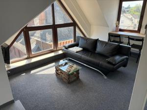 a living room with a black leather couch and a table at Appartement am Peterstor in Montabaur