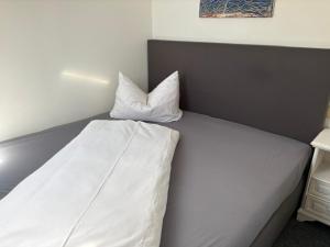 a white bed with two pillows on top of it at Appartement am Peterstor in Montabaur