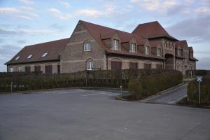 a large brick building with a red roof at PS Orion in Wenduine