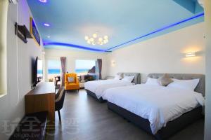 two beds in a hotel room with a view of the ocean at 墾丁 後灣 微風海岸海景民宿 in Checheng +42 photos